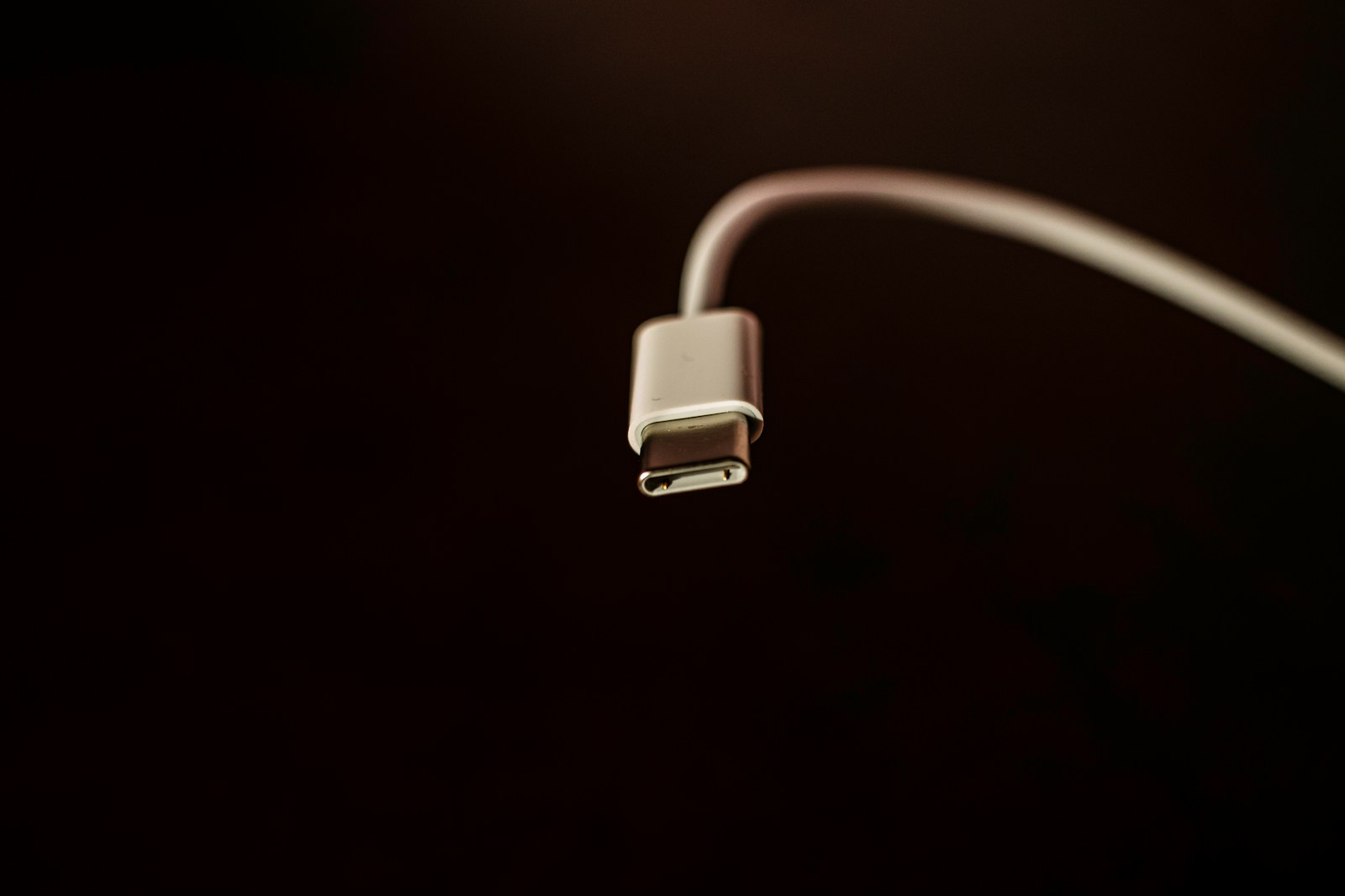 A white USB-C cable on a dark background — the universal port MCP wants to be for AI. Photo by Mishaal Zahed on Unsplash.