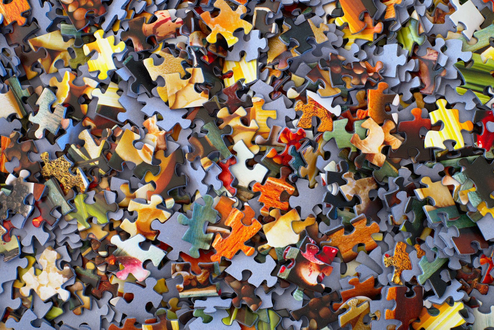 Pile of multicoloured jigsaw puzzle pieces — modular content blocks ready to assemble.